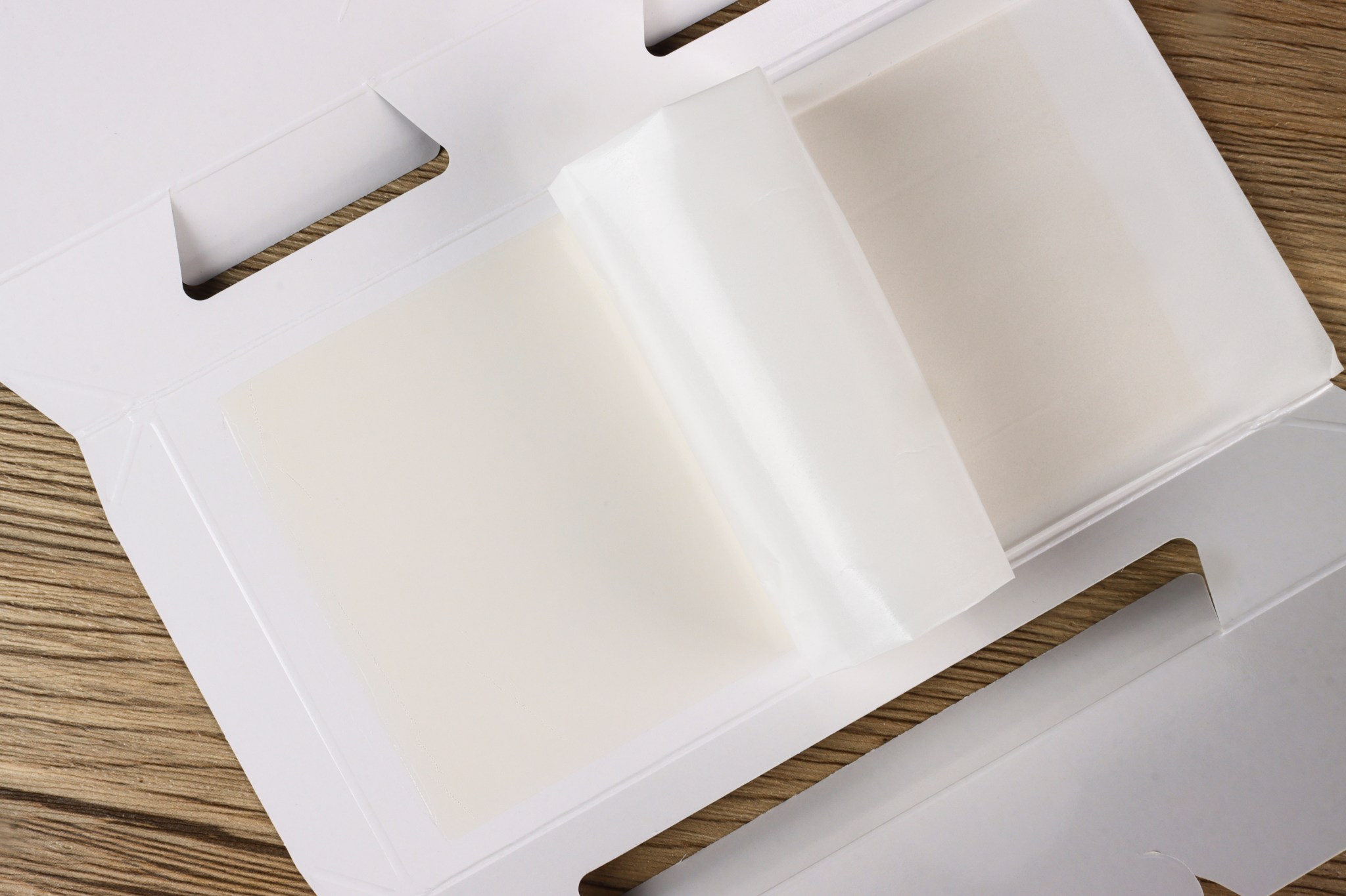 Die-cut board with the release film lifted to show the glue panel